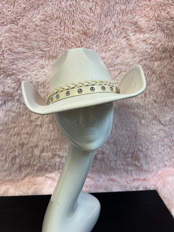 -faux suede cowboy hat in ivory
-all ivory faux leather band with braided and silver studded detail
-interior ribbon inside hat to customize size
-stiff, sturdy structure