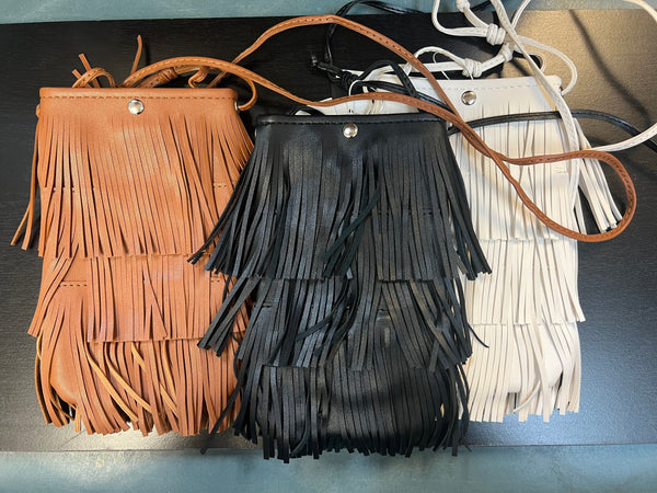 Sidesaddle Fringe Bag Ivory
-Ivory Faux Leather with 3 layers of fringe
--thin strap, cross body bag
- silver snap closure
- one compartment inside
- approximately 4.5' wide, 8" tall, no gusset
-usable interior space will be smaller due to snap closure
