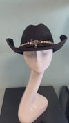 buckaroo straw black cowboy hat
-straw cowboy hat in black
-studded, braided, black and white band with silver bull
- moldable wire brim for customizable shape
-interior ribbon inside hat to customize size