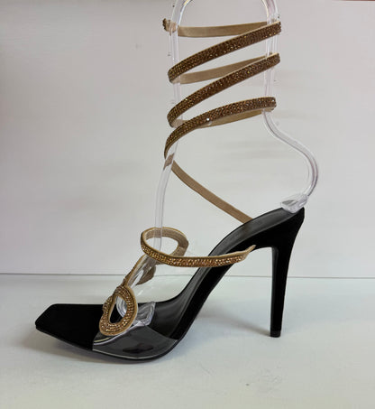 LACEY-35 BLACK STILETTO HEEL WITH GOLD RHINESTONE ASSYMETRICAL SERPENT DESIGN ON CLEAR VAMP AND SPIRAL ANKLE STRAP