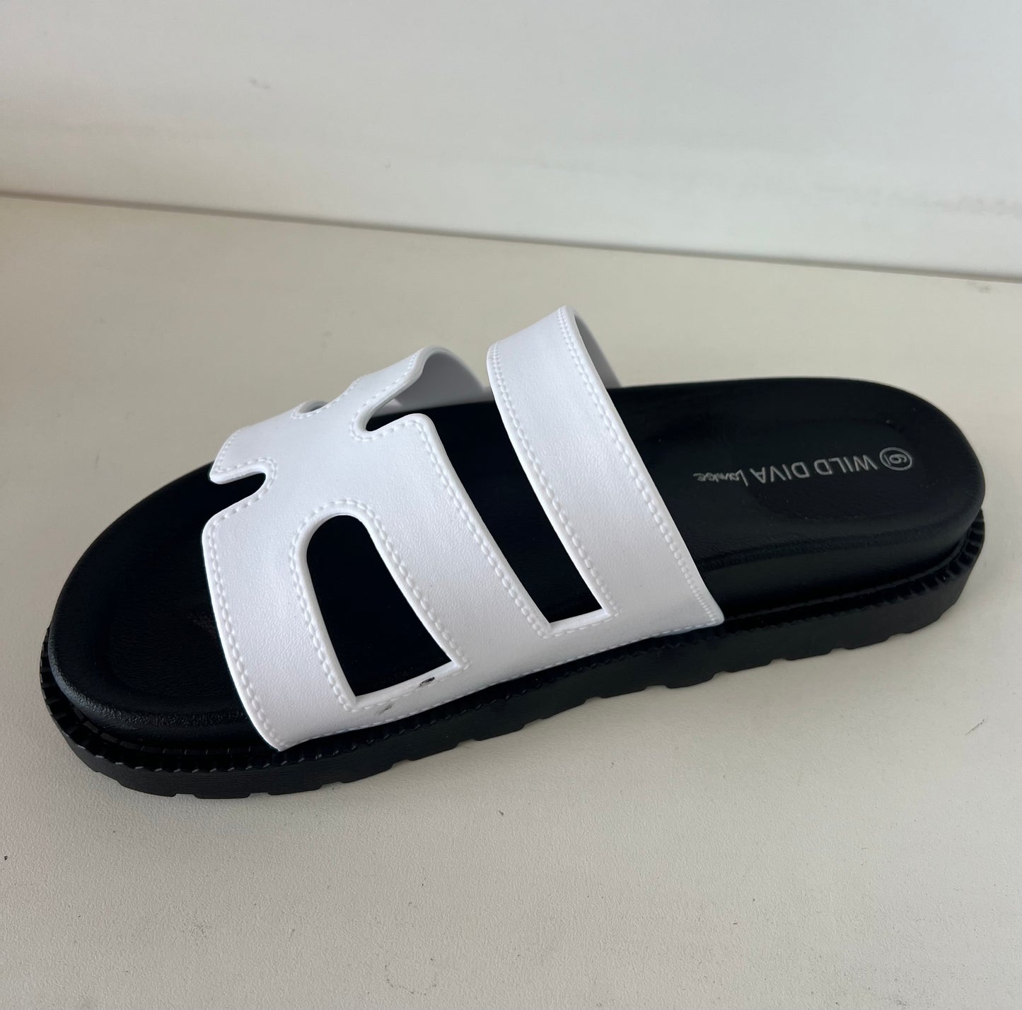 GINO-24 white

- White Sandal
- Open Toe
- Cutout Vamp Detail
- Slip-On Slide
- Flatform Sole, Approx. 1"
- Whole Sizes Only