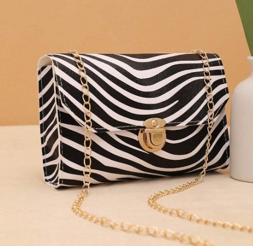 LYRA ZEBRA BLACK AND WHITE BAG WITH GOLD CLASP AND CROSS BODY STRAP