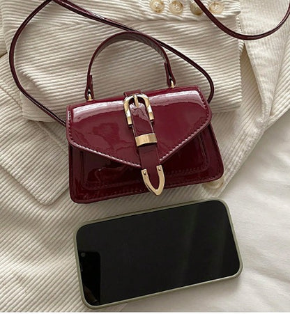 MORGAN BURGUNDY PATENT LEATHER CROSS BODY BAG WITH GOLD BUCKLE DETAIL