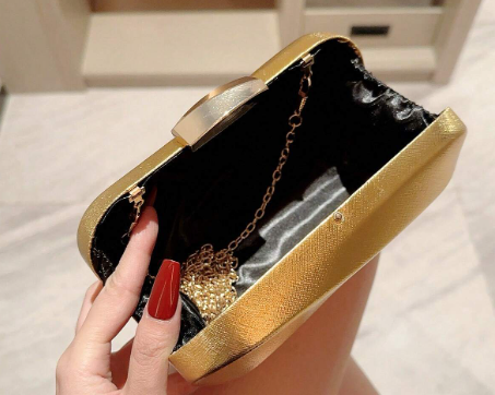 ORLA GOLD HARD CASE CLUTCH WITH SHINY METALLIC FABRIC OVER A MOULDED GEOMETRIC DESIGN