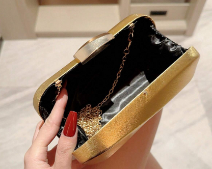 ORLA GOLD HARD CASE CLUTCH WITH SHINY METALLIC FABRIC OVER A MOULDED GEOMETRIC DESIGN