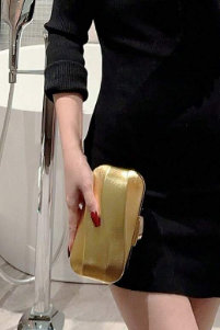 ORLA GOLD HARD CASE CLUTCH WITH SHINY METALLIC FABRIC OVER A MOULDED GEOMETRIC DESIGN