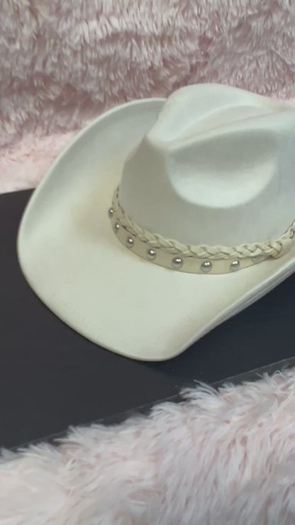 -faux suede cowboy hat in ivory

-all ivory faux leather band with braided and silver studded detail

-interior ribbon inside hat to customize size

-stiff, sturdy structure