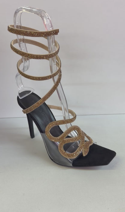 LACEY-35 BLACK STILETTO HEEL WITH GOLD RHINESTONE ASSYMETRICAL SERPENT DESIGN ON CLEAR VAMP AND SPIRAL ANKLE STRAP