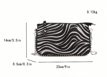 TARA ZEBRA FAUX LEATHER RECTANGULAR CLUTCH WITH SILVER STUDDED BORDER AND REMOVEABLE CHAIN STRAP