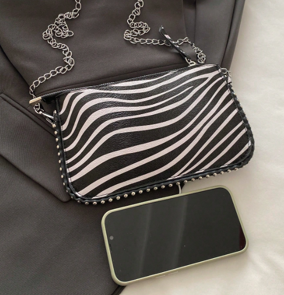 TARA ZEBRA FAUX LEATHER RECTANGULAR CLUTCH WITH SILVER STUDDED BORDER AND REMOVEABLE CHAIN STRAP