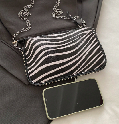 TARA ZEBRA FAUX LEATHER RECTANGULAR CLUTCH WITH SILVER STUDDED BORDER AND REMOVEABLE CHAIN STRAP