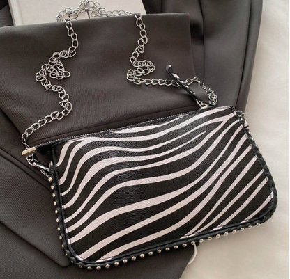 TARA ZEBRA FAUX LEATHER RECTANGULAR CLUTCH WITH SILVER STUDDED BORDER AND REMOVEABLE CHAIN STRAP