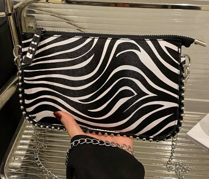 TARA ZEBRA FAUX LEATHER RECTANGULAR CLUTCH WITH SILVER STUDDED BORDER AND REMOVEABLE CHAIN STRAP
