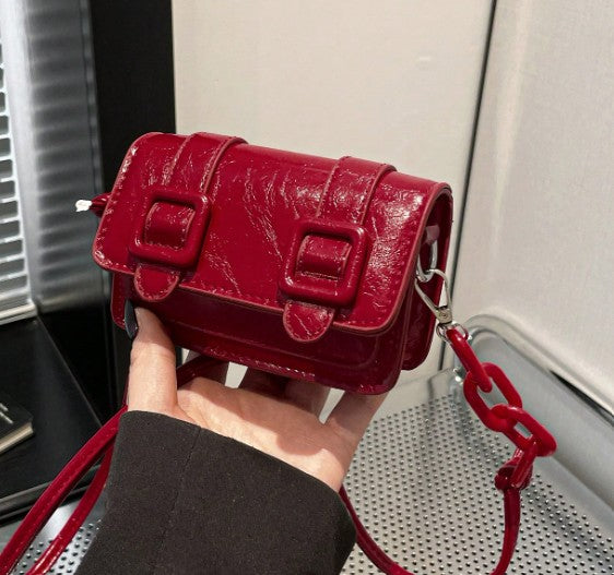 TRINA WINE MINI BAG WITH DOUBLE BUCKLE DESIGN AND CROSS BODY STRAP